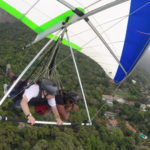 Mark flying over Rio with control of the hangglider, flying so well his pilot has fallen asleep!