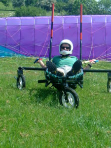 The swanton paragliding wheelchair on the ground prior to launch with a pilot ready to be towed into the air.